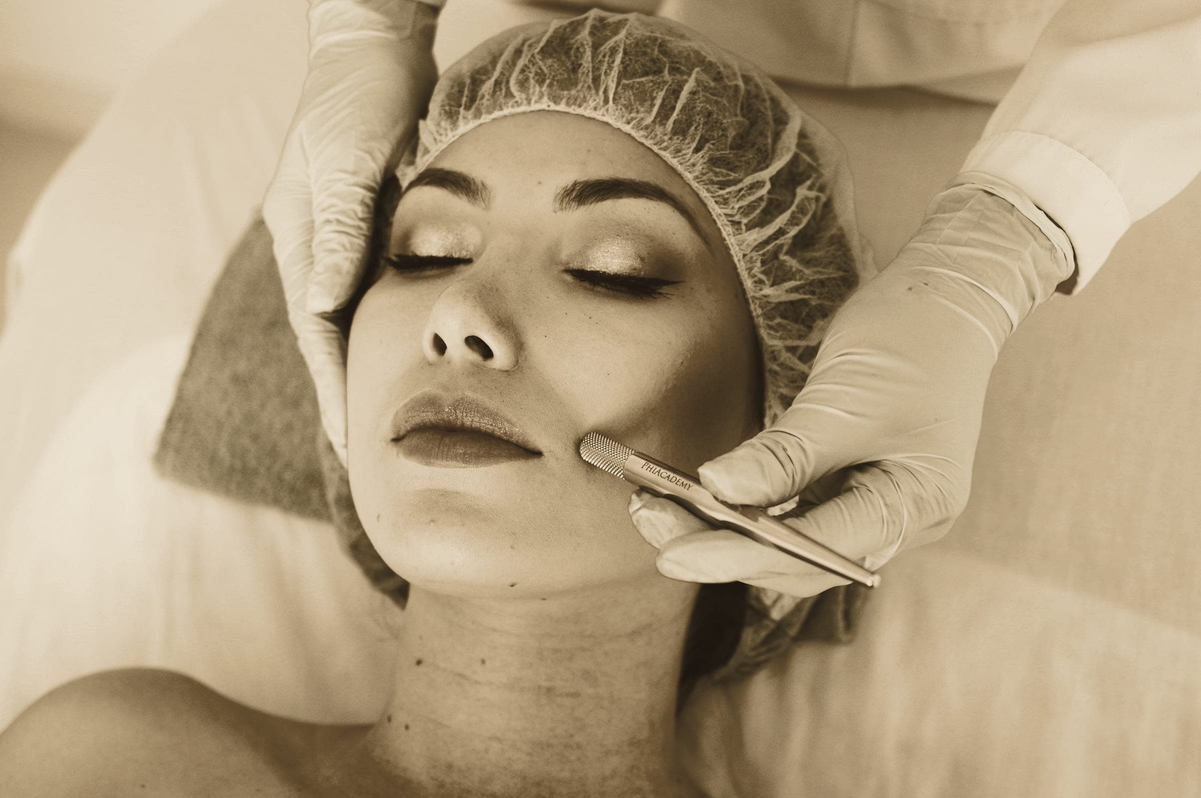 A practitioner's gloved hands resting on a patient's face during an assessment.
